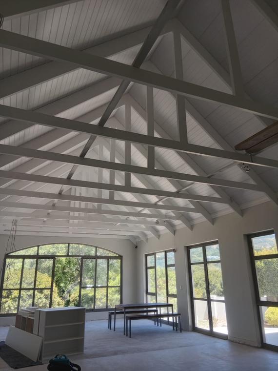 Vaulted ceiling with painted exposed timber trusses and boarding