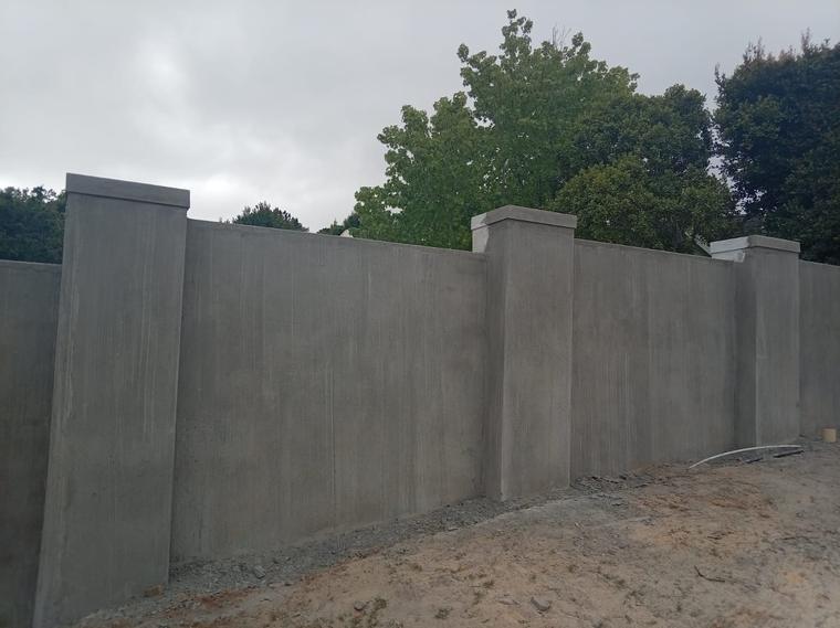 Completed off-shutter concrete boundary wall with capped piers