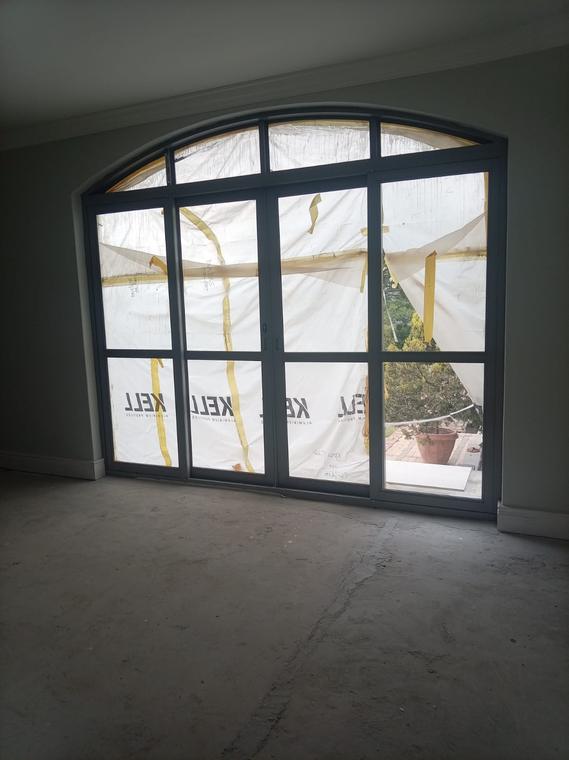 Arched-head aluminium sliding door set installed in a painted opening