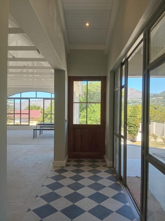 Entrance hall with blue and white chequerboard tiled floor and hardwood door