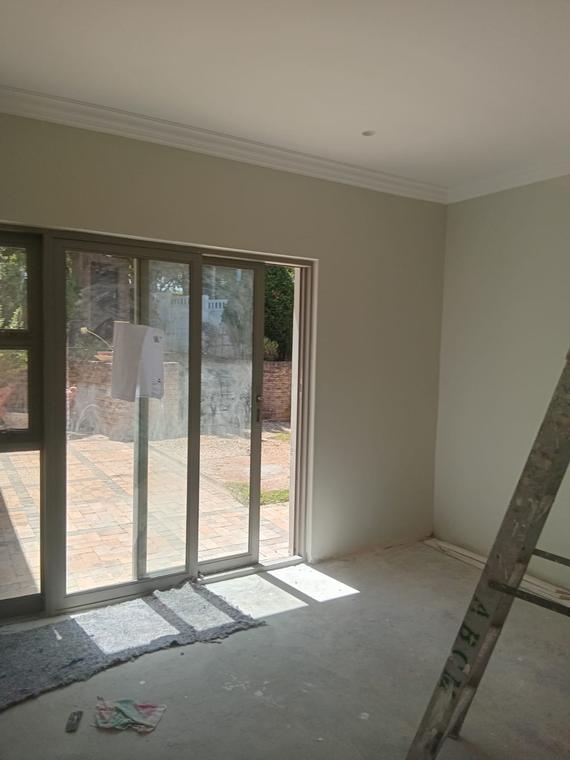 Freshly painted room with stacking sliding doors onto brick paving